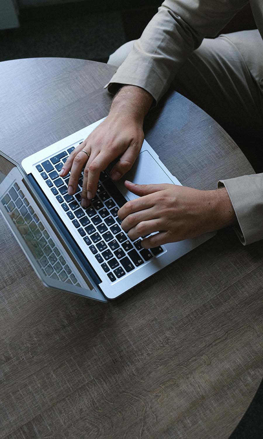 Person typing on a laptop on a wooden surface representing home networking services